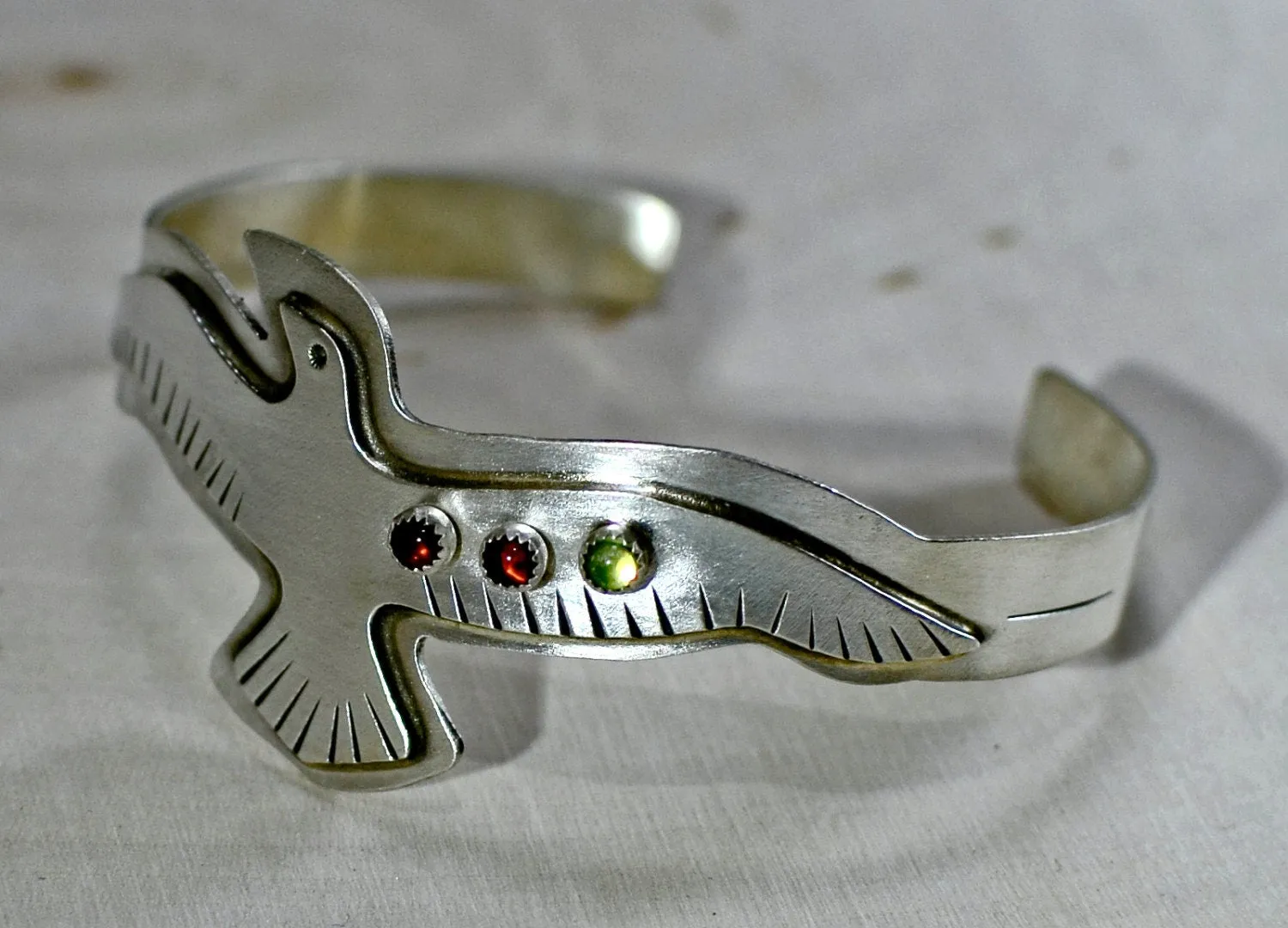 Sterling silver bird bracelet with red Garnet and green Peridots