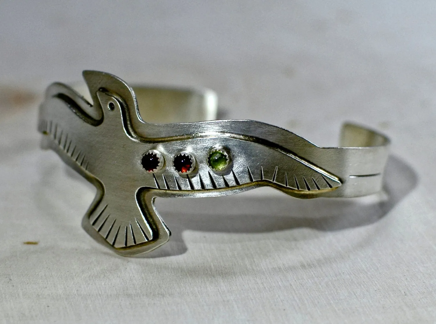Sterling silver bird bracelet with red Garnet and green Peridots